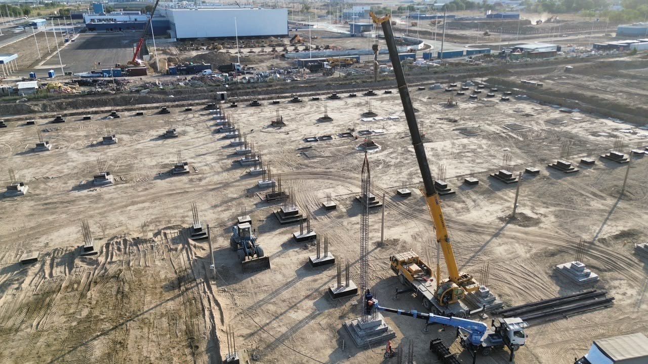 Автокран устанавливает арматурный каркас колонны на стакан